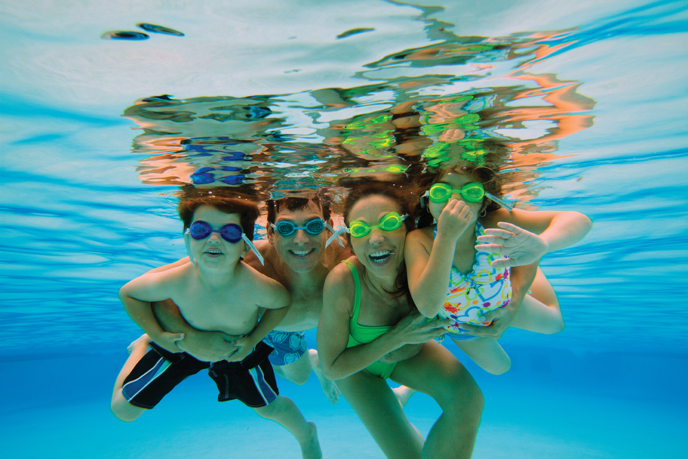 Family Swimming In Pool