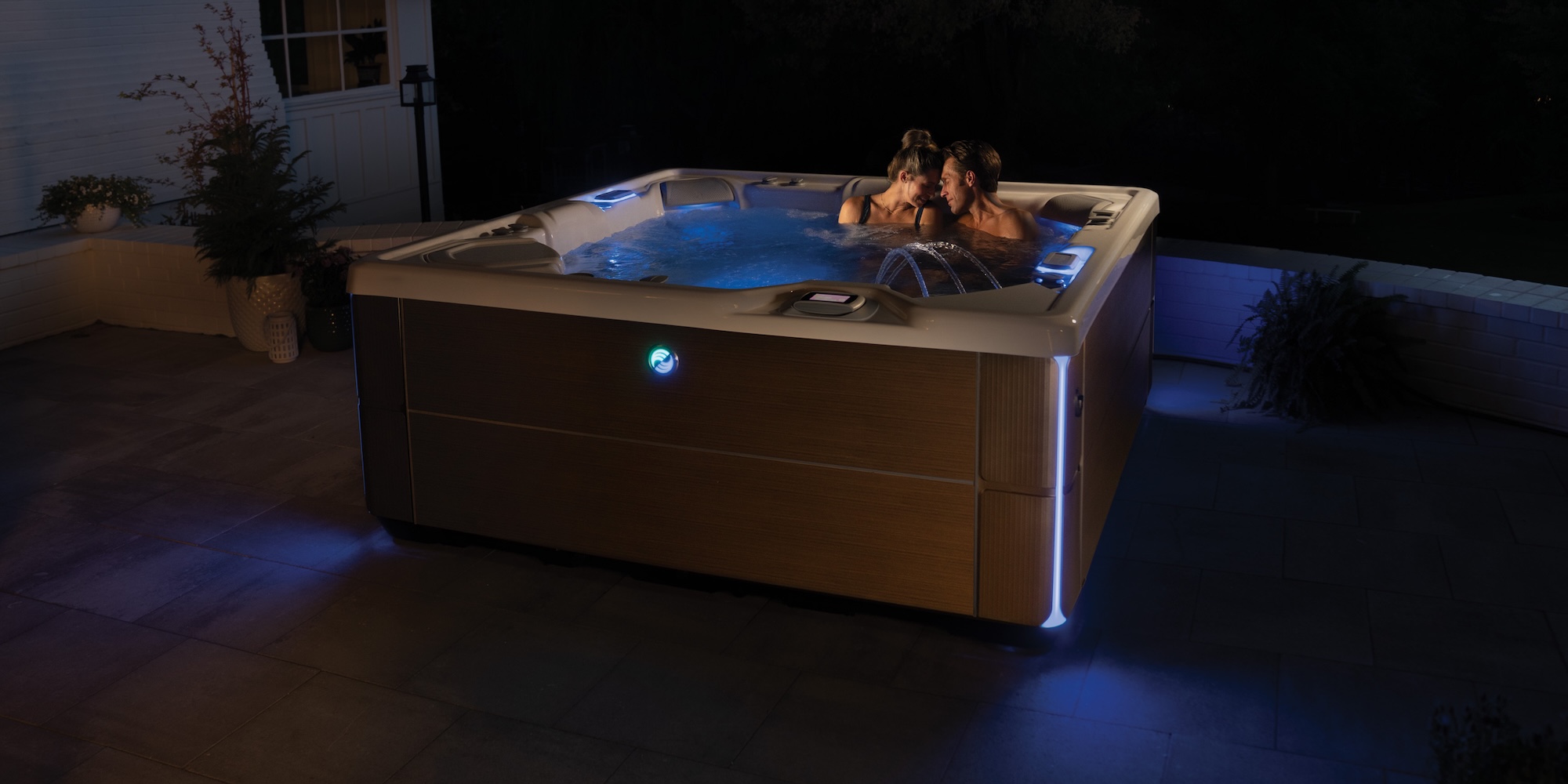 Hot Spring Highlife Vanguard spa lit at night on a patio