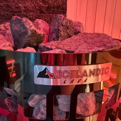 Backlit Himalayan salt rock glowing pink inside a sauna cabin
